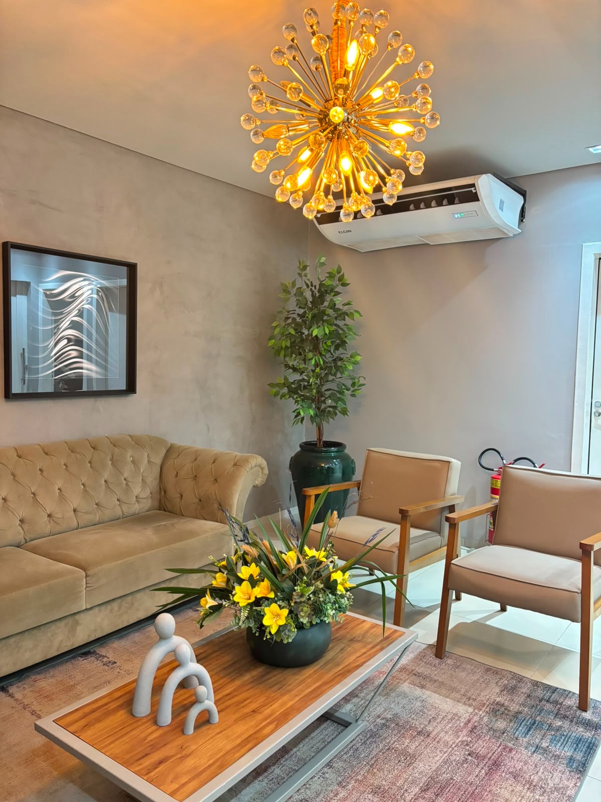 Sala de espera da Clínica Modellen com sofá e iluminação em dourado